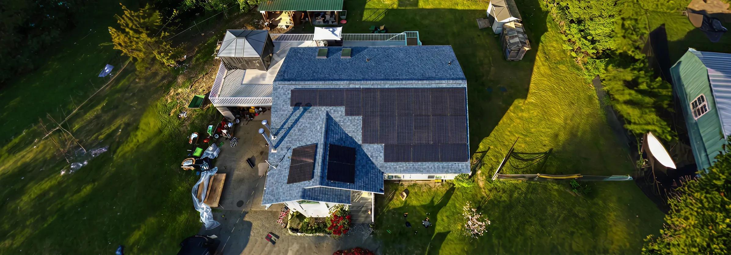 Aerial view of a high-efficiency residential solar panel installation on a modern teal metal roof in British Columbia, designed for coastal climate durability.