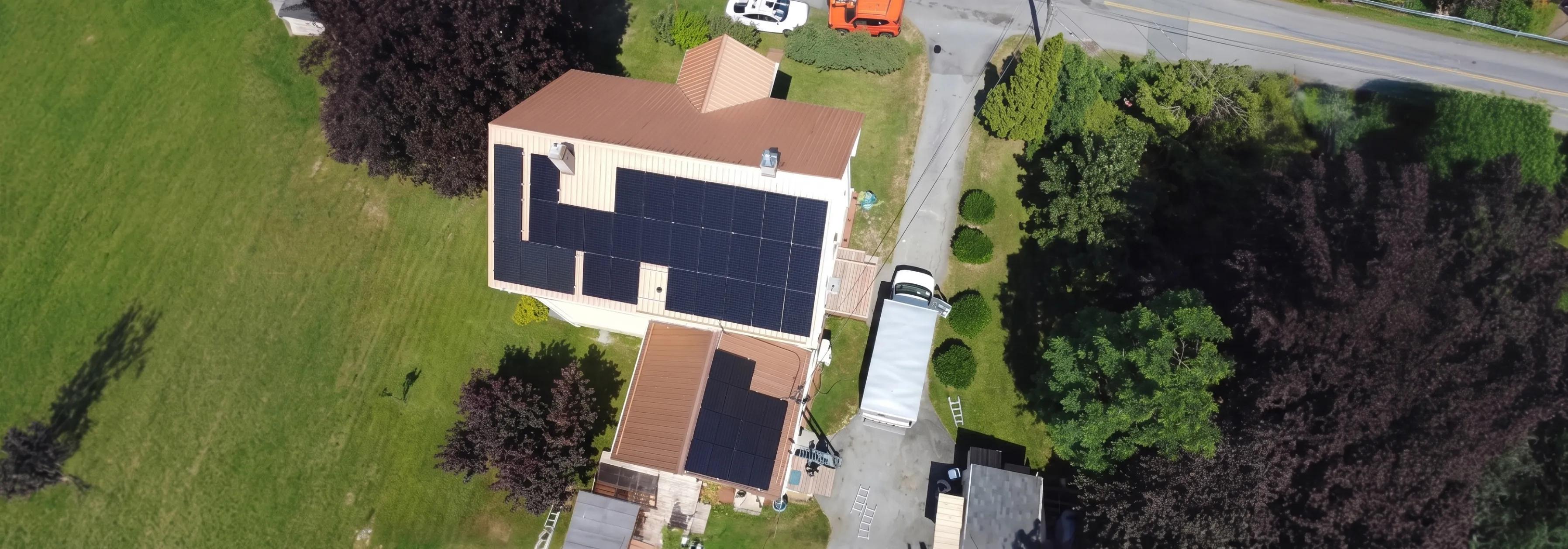 Aerial view of a large residential solar panel installation on a Halifax home, optimized for Nova Scotia’s net metering program to reduce monthly power bills.