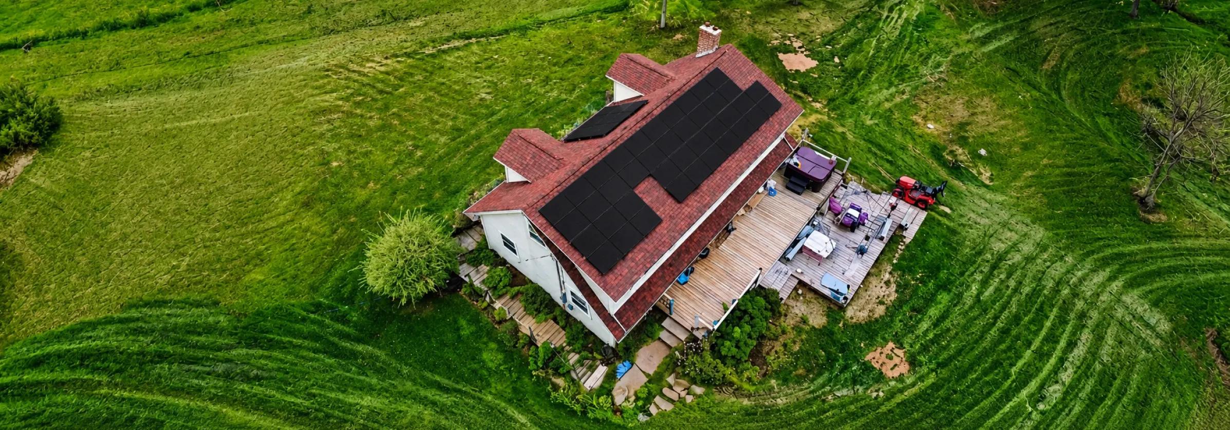 High-performance solar panels installed on a classic red metal roof in rural Prince Edward Island, designed for coastal durability and high-yield production.