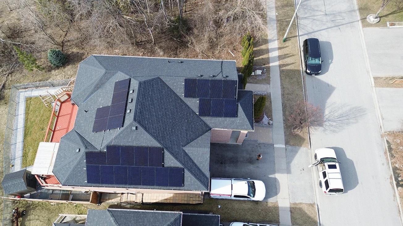 Aerial view of an Ontario home with a high-performance residential solar and battery system, featuring sleek black panels and $13,200 in available rebates.