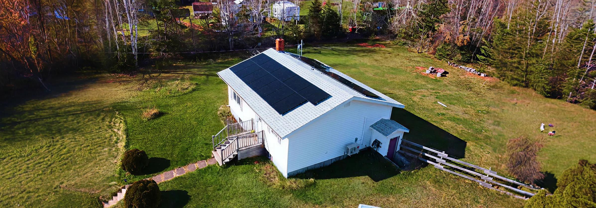 A high-efficiency residential solar panel installation on a white bungalow in New Brunswick, designed to maximize savings through the NB Power net metering program.