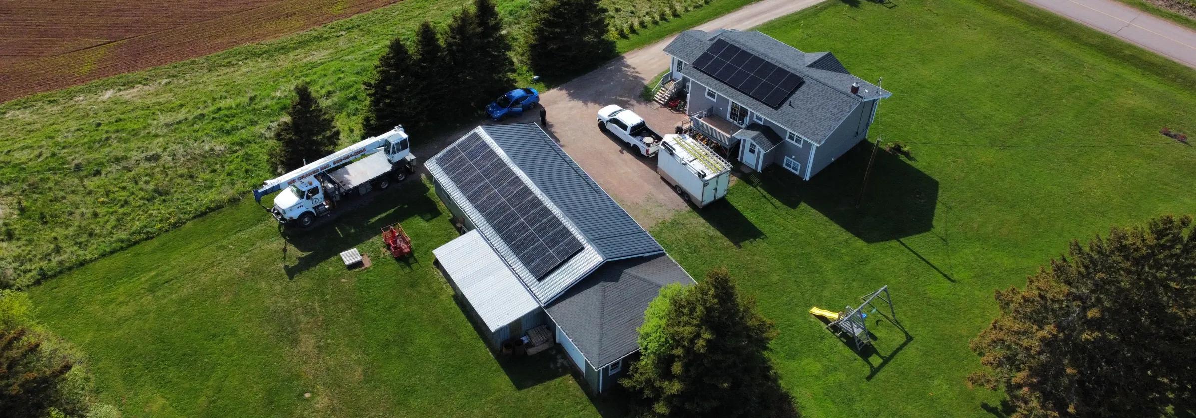Aerial view of black solar panels on a New Brunswick home with a backyard pool, showcasing a full turnkey solar energy solution for residential property owners.