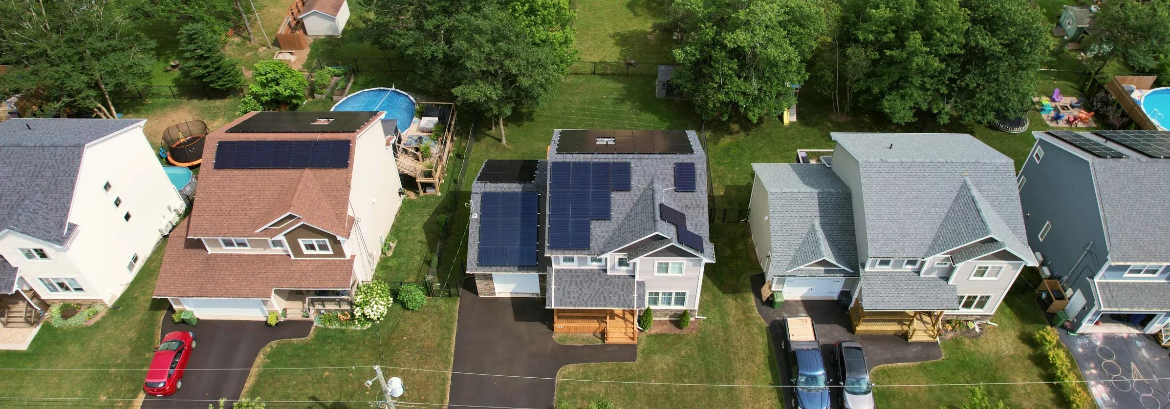 Large-scale solar array on a New Brunswick multi-unit residential complex, demonstrating how solar power reduces shared utility costs for housing providers.