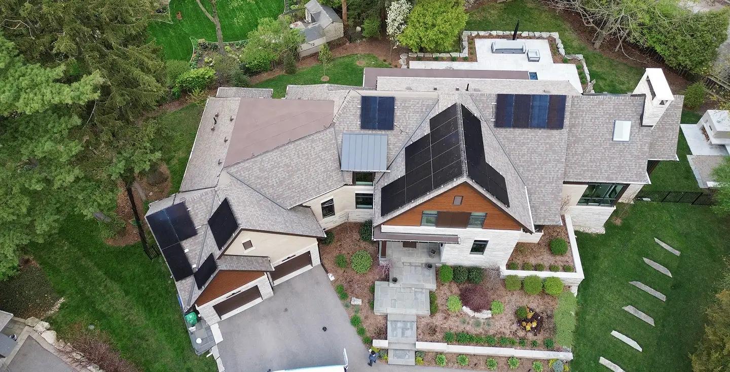 High-efficiency Ontario solar and battery installation featuring a modern suburban home and a large-scale commercial rooftop solar array.