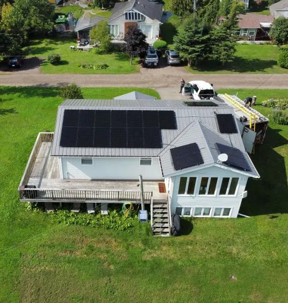High-angle shot of a modern New Brunswick home featuring an integrated solar and battery storage system for storm resilience and long-term energy independence.