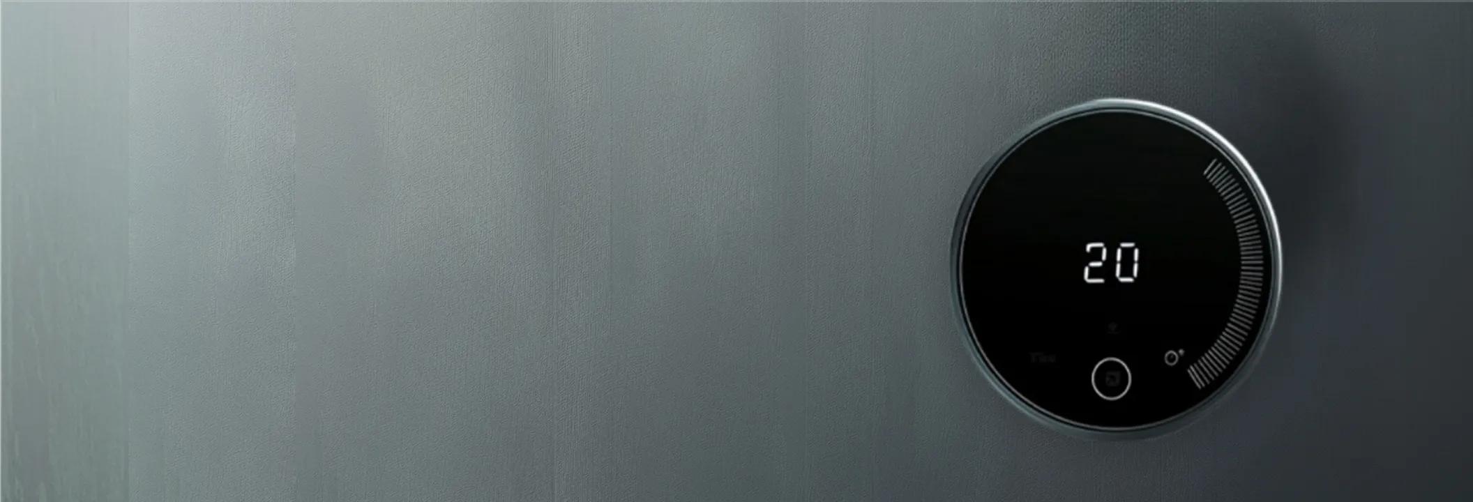 A close-up of a modern, round black smart thermostat digital display mounted on a wall showing a indoor temperature setting of 20 degrees.