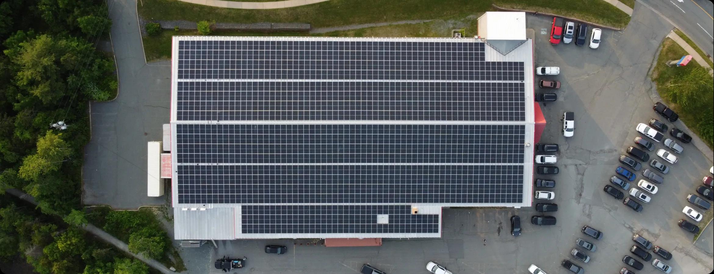 Community building with solar panels installed across its pitched roof.