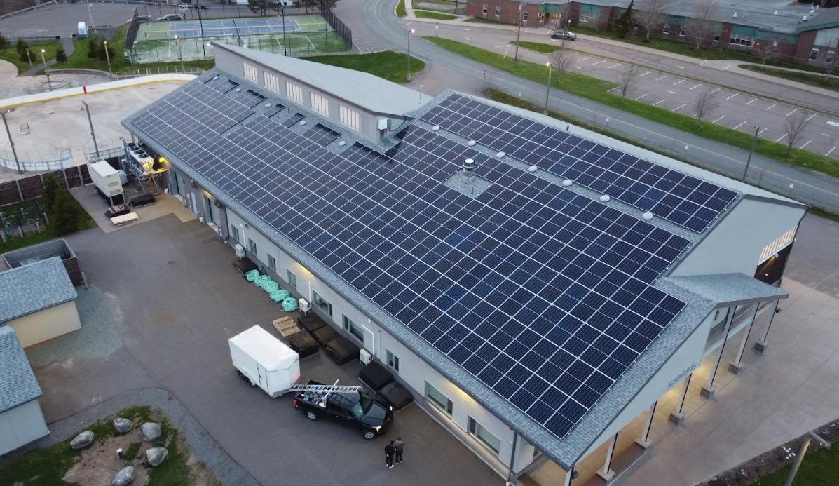 Solar panels installed across the roof of a municipal building.