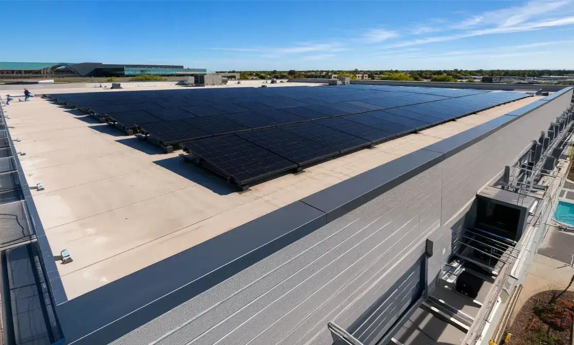 Aerial view of a building complex with solar arrays across its flat roofs.