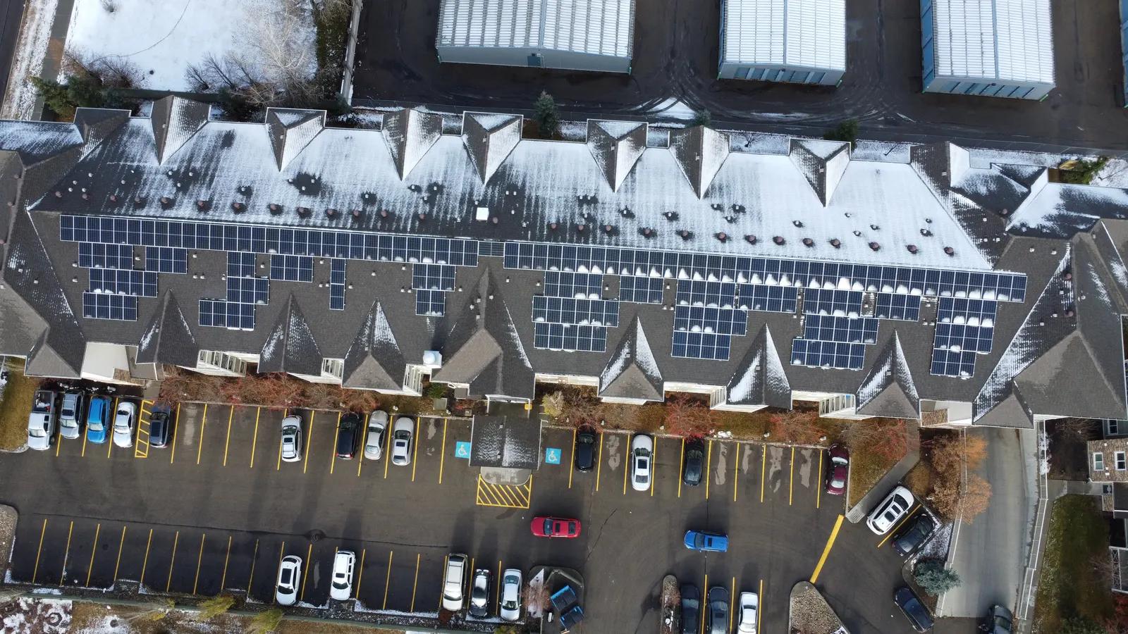 Aerial view of multi-family housing with rooftop solar panels