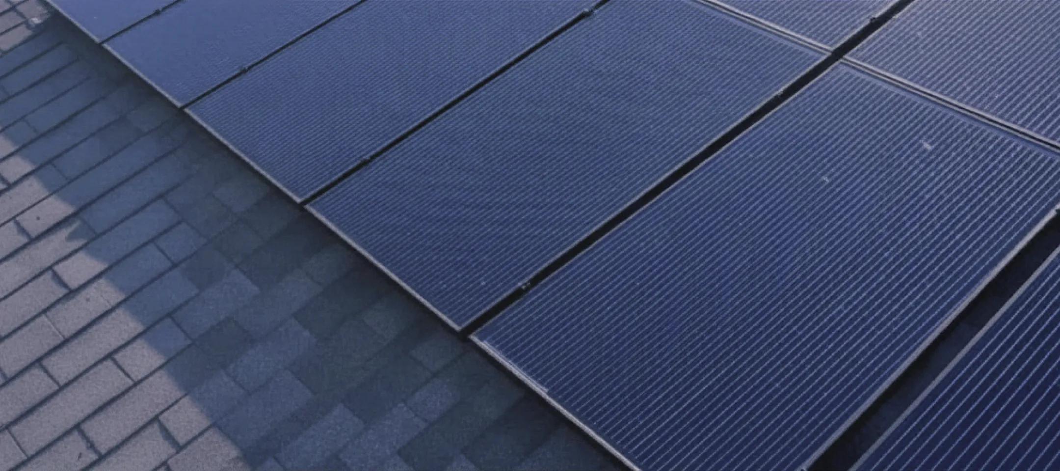 Close-up shot of sleek, high-efficiency dark monocrystalline solar panels installed on a residential roof